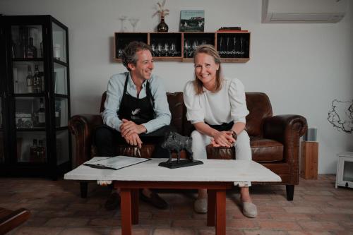 a man and a woman sitting on a couch at SOEDER Countryhouse & Kitchen in Båstad