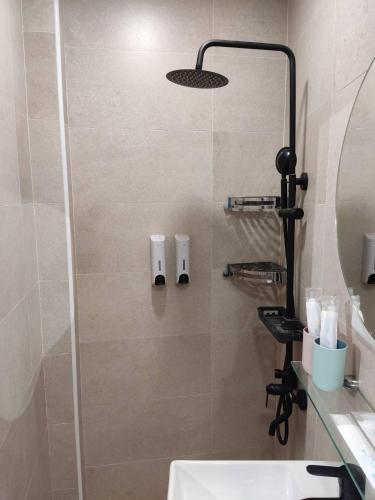 a bathroom with a shower with a sink and a mirror at 竹南橘子民宿 in Zhunan