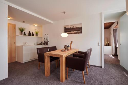 a dining room with a wooden table and black chairs at Hotel Krone in Schruns-Tschagguns