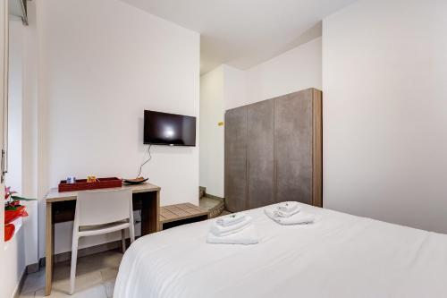 una camera da letto con un letto, una scrivania e una TV di B&B Casa Der Poeta a Roma