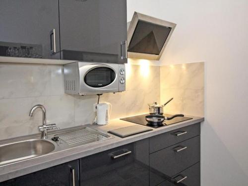 małą kuchnię ze zlewem i kuchenką mikrofalową w obiekcie Ferienwohnung Klimt w Wiedniu