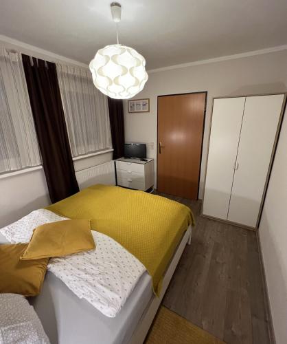 a bedroom with a bed with a yellow blanket at Südhang FeWo in Murau