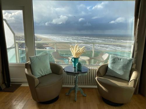 Um quarto com duas cadeiras e uma mesa com vista para o oceano. em Annet's Studio em Zandvoort