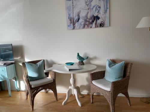 biały stół z dwoma krzesłami i stół z dwiema poduszkami w obiekcie Annet's Studio w Zandvoort