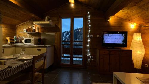 une cuisine avec une télévision et une table avec une table sidx sidx sidx dans l'établissement mini duplex dans chalet, à Saint-François-Longchamp