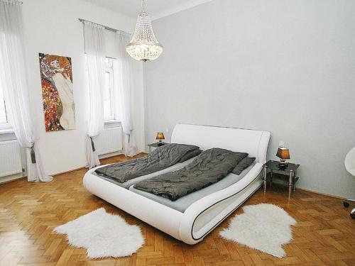 a white bed in a room with two white rugs at Ferienwohnung Urban-Loritz in Vienna
