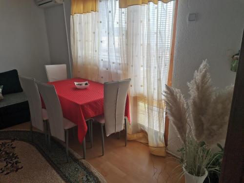 une salle à manger avec une table et des chaises rouges dans l'établissement Apartman Hill, à Sarajevo