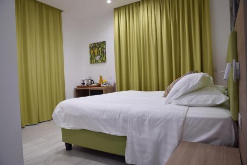 a bedroom with a large bed with green curtains at Casa Marino in Sorrento