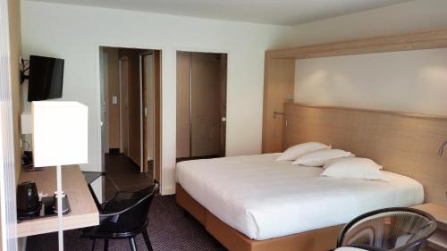 a bedroom with a large white bed with a wooden headboard at Loire & Sens in Juigné-sur-Loire