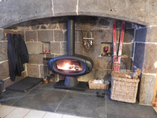 - un four en pierre avec une cheminée dans l'établissement Le Figarelou, à Thiézac