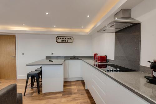a kitchen with white cabinets and a counter top at The Picture House Apartments in Liverpool