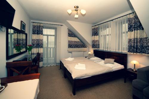 a bedroom with two beds and two windows at Gościniec Molo in Mrągowo