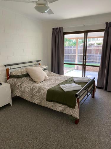 a bedroom with a bed and a large window at Coastal Soul STA - MTA in Tin Can Bay