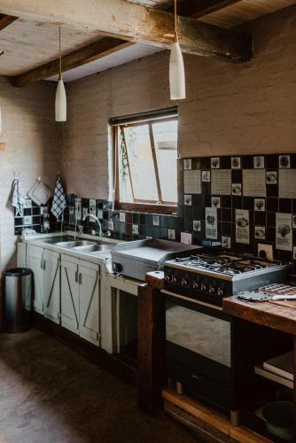 a kitchen with a stove and a sink at African Leaves Trout Lodge in Dullstroom