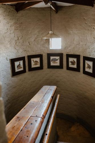 a room with a wooden table and pictures on the wall at African Leaves Trout Lodge in Dullstroom