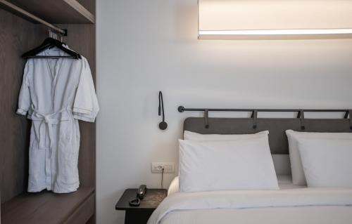 a bedroom with a bed and a hanging robe at Bitzaro Boutique Hotel in Zakynthos Town
