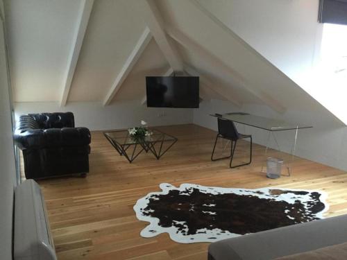 a living room with a black couch and a glass table at Solar Do Castelo - Melgaço in Melgaço