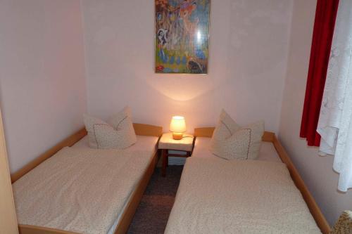 two beds in a room with a lamp on it at Ferienwohnung Tor zur Ostsee - a55965 in Mellenthin