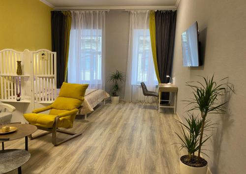 a living room with a yellow chair and a couch at In the heart of Odessa in Odesa