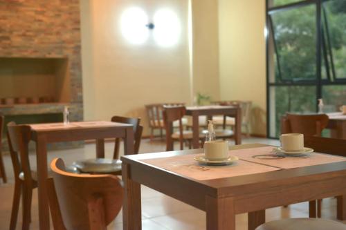 a dining room with wooden tables and chairs and windows at Tekoa Lodge in Puerto Iguazú