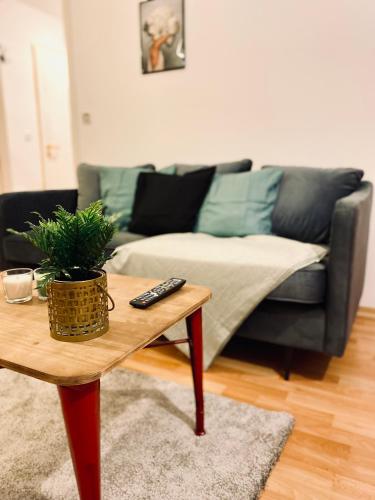 a living room with a couch and a coffee table at Saniertes Studio - Elisa - mit Balkon, WLAN, Smart-TV & Küche in City-Nähe in Erfurt