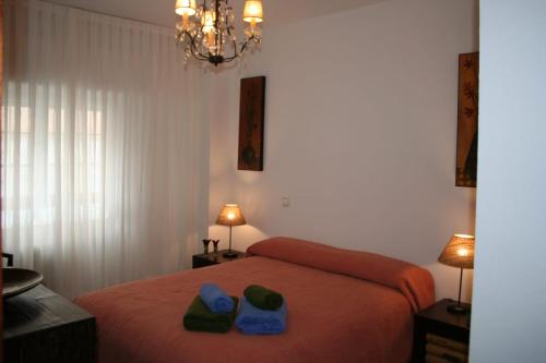 a bedroom with a bed with two hats and towels on it at Alojamiento Adelfas in Madrid