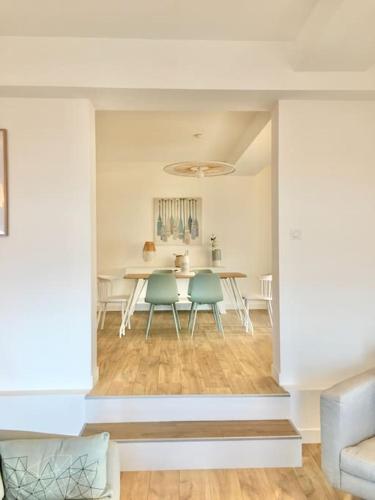 a living room with a table and two chairs at L'appartementducroisic - Sur le port, vue mer in Le Croisic