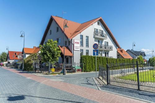 a building with an orange roof on a street at Pokoje gościnne Nord in Krynica Morska