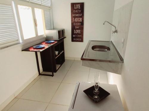 a small kitchen with a sink and a table at Casa Petit - Banheiro Exclusivo in Natal
