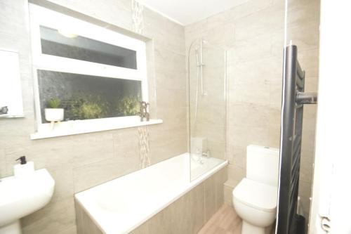 a bathroom with a sink and a toilet and a window at Natural Sanctuary 4 Bedroom - SuiteLivin in Felling