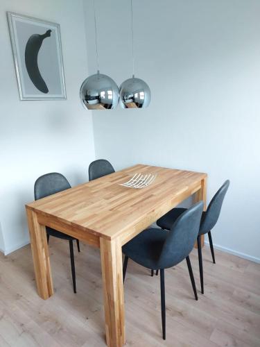 a wooden dining table with black chairs around it at Landpartie in Freckenfeld