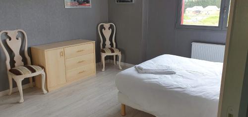 a bedroom with two chairs and a bed and a dresser at Appartement 4 chambres Sur la Cave in Givet