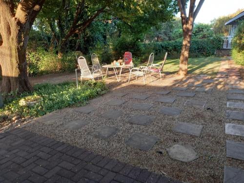 a patio with chairs and a table in a yard at CREDO Guest House in Bloemfontein