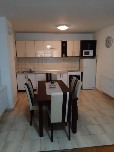 a kitchen with a table and chairs in a room at Apartman Neda in Kupres