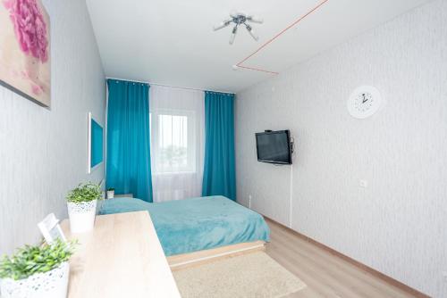 a bedroom with a blue bed and a tv at Гостиница Пермь Апарт-Отель SC in Perm