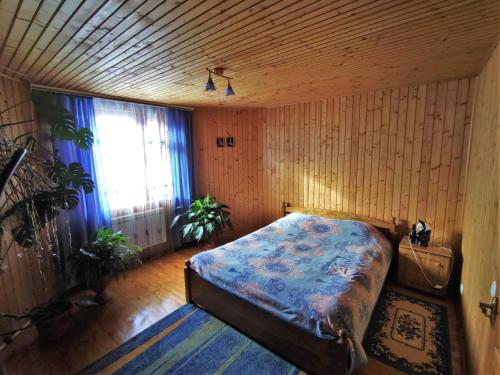 a bedroom with a bed in a room with wooden walls at Guesthouse U dida Viktora in Yaremche