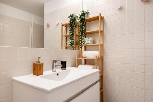 ein Badezimmer mit einem weißen Waschbecken und einem Spiegel in der Unterkunft Elegant studio & private garden in historical centre in Porto