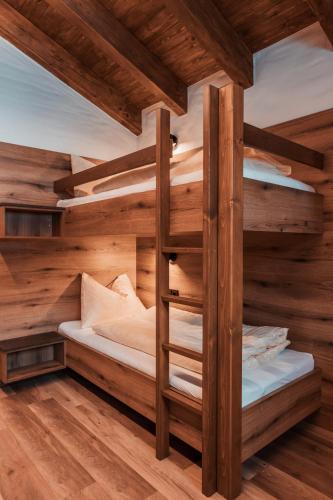 two bunk beds in a room with wooden walls at Bergkristall in Gosau