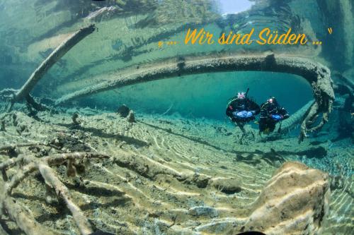 two people in a dugout in the ocean at Ferienwohnungen im Haus Sonnleiten am Weissensee in Techendorf