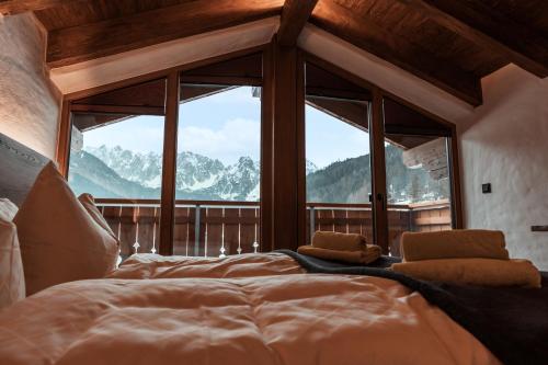 1 dormitorio con 1 cama grande frente a una ventana en Bergkristall en Gosau