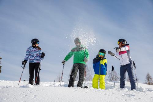 a group of people standing on a snow covered slope at Ferienwohnungen im Haus Sonnleiten am Weissensee in Techendorf