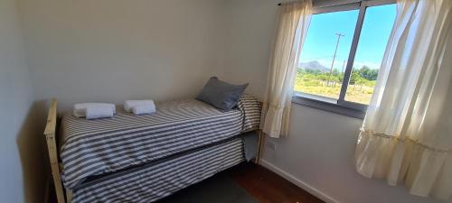 a small bed in a room with a window at Puesto El Arroyito in Tunuyán