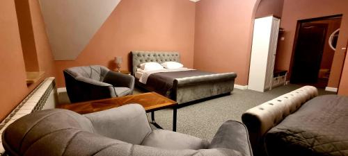 a living room with couches and a bed and chairs at PAŁAC FABRYKANTA in Myszków