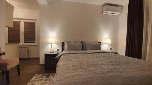 a bedroom with a large bed and two lamps at IRIS Apartments in Bitola
