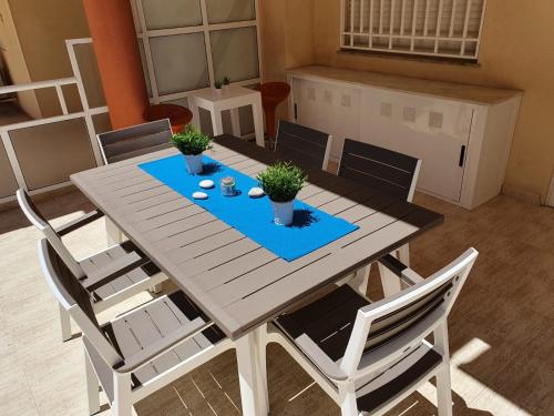 a wooden table and chairs with plants on it at APARTAMENTO CON GRAN TERRAZA, PISCINA Y CON VISTAS AL MAR, A SOLO 50 m DE LA PLAYA in Daimuz