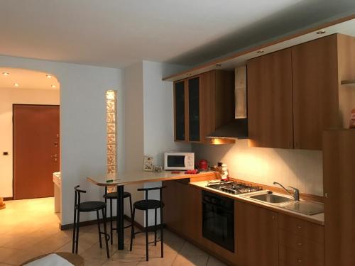 a kitchen with wooden cabinets and bar stools at NANDO in Bellagio