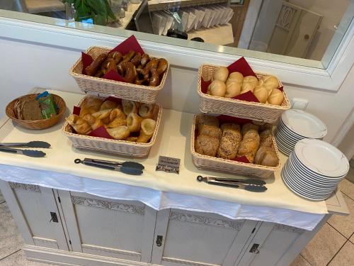 three baskets of bread and pastries on a counter at Hotel garni St.Georg in Sankt Wolfgang