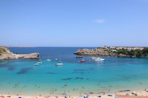 a group of people on a beach with boats in the water at Belvedere, Family-friendly, Nice, First-line Apartment with Stunning Beach and Sea views,AC in Arenal d'en Castell