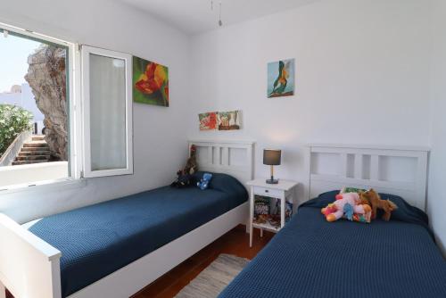 a bedroom with two beds and a window at Belvedere, Family-friendly, Nice, First-line Apartment with Stunning Beach and Sea views,AC in Arenal d'en Castell