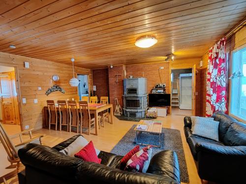 a living room with a couch and a dining room at Lake Cottage Jänisvaara in Kolinkylä